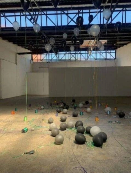 Balloons scattered in a warehouse as part of the installation